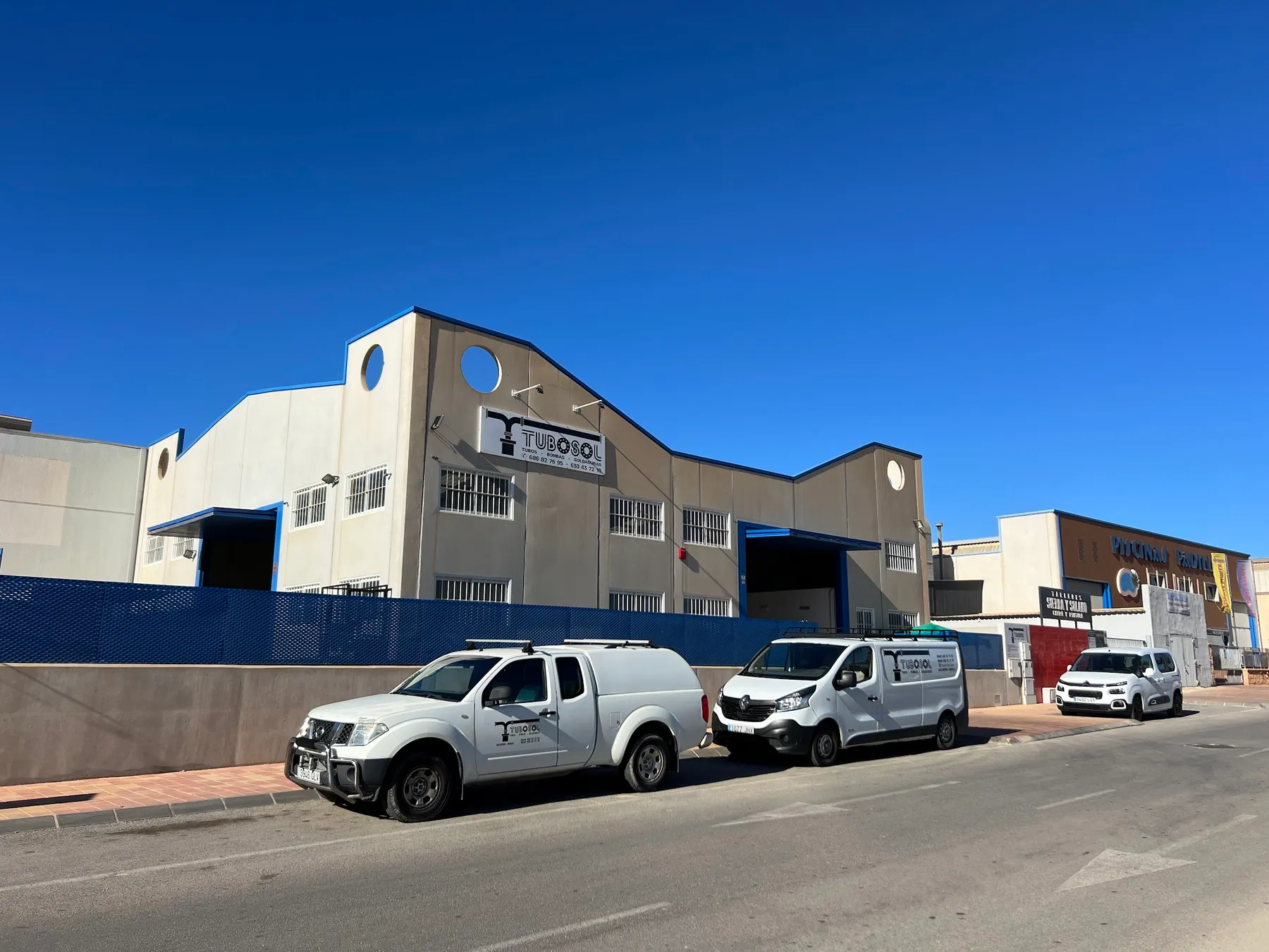 Nave de Tubosol con su rótulo y las furgonetas rotuladas aparcadas