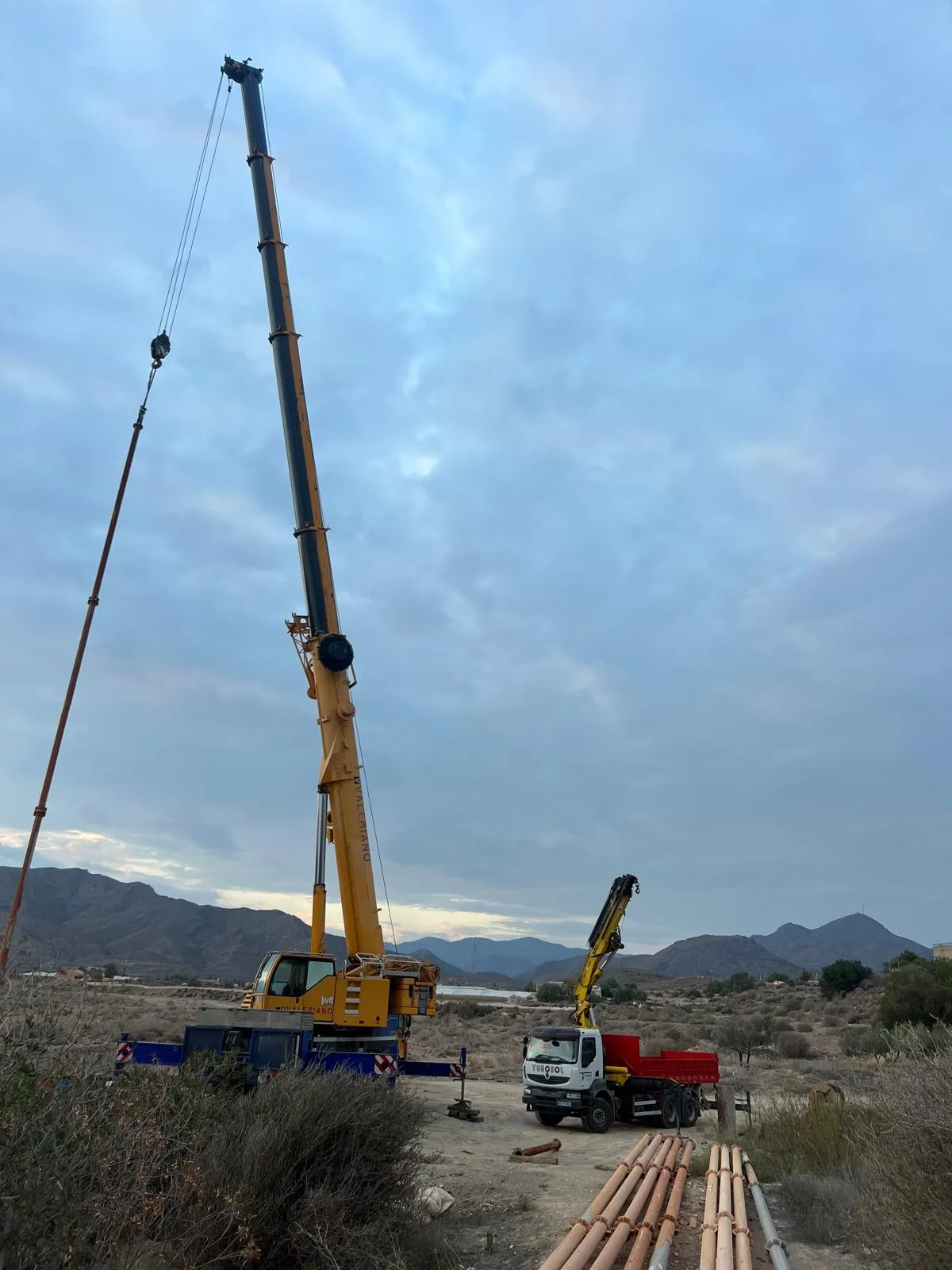 Camión de Tubosol trabajando en una obra junto a una grúa de gran tonelaje